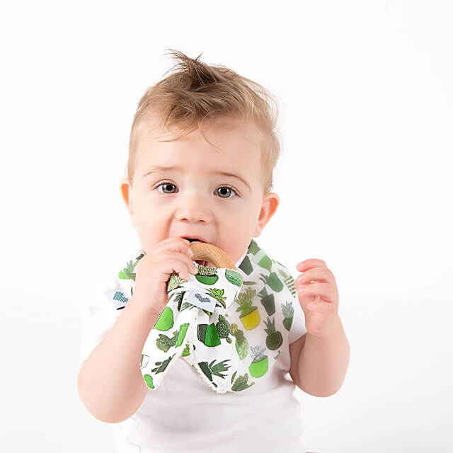 Baby with wooden bunny teething toy in cactus print