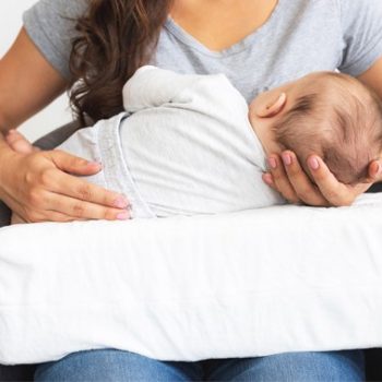 nursing pillow with baby while feeding